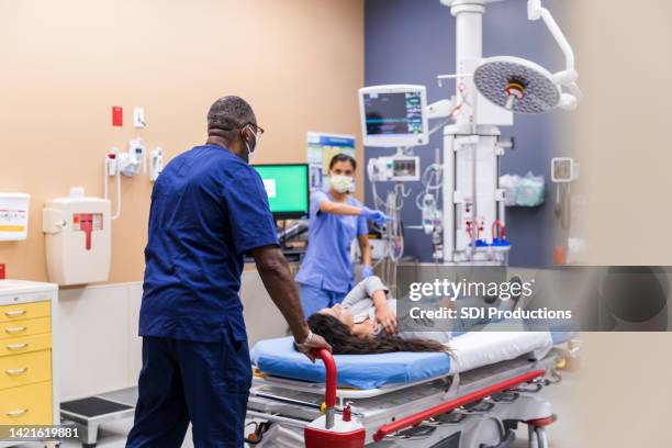 nurse gives orderly directions when he wheels in patient - hospital orderly stock pictures, royalty-free photos & images