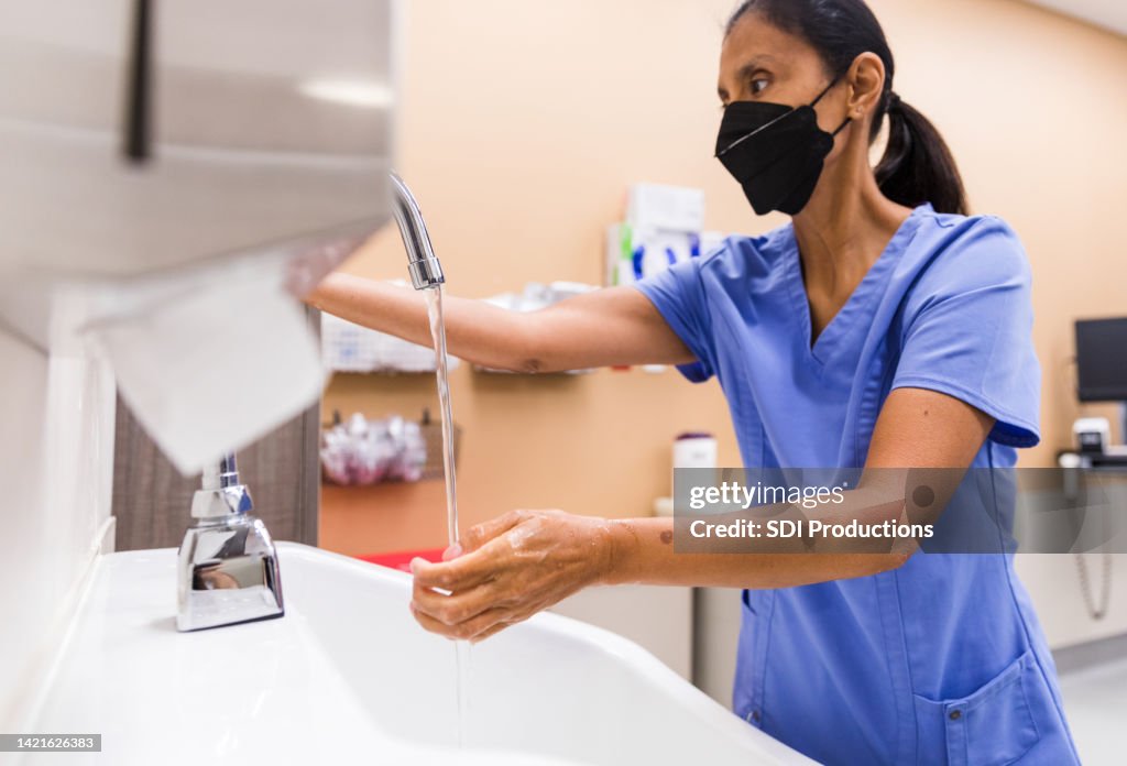 Surgeon washing her hands in the patient's hospital room