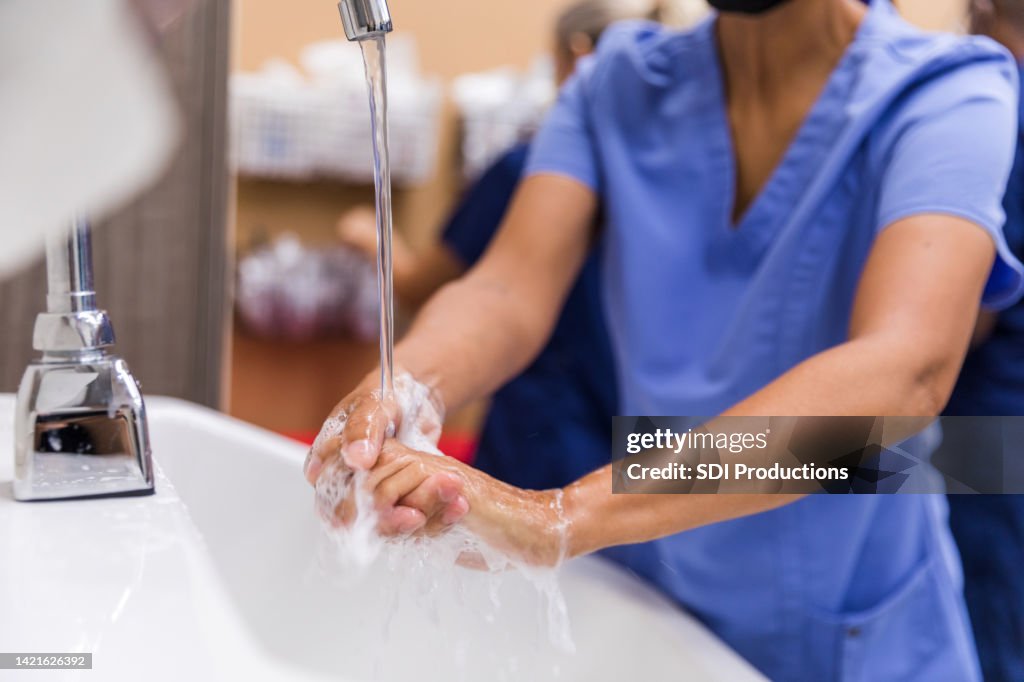 Personnel médical méconnaissable se lavant les mains