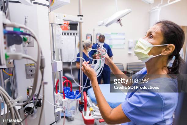 nurse prepares monitoring equipment - critical care bildbanksfoton och bilder