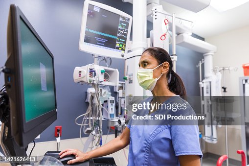 Nurse Using Tech Nurse Uses Computer To Review Medical Chart High-Res Stock Photo ...