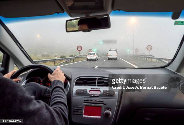car point of view driving, driver passing a truck on a rainy two-lane highway. - parabrisas fotografías e imágenes de stock