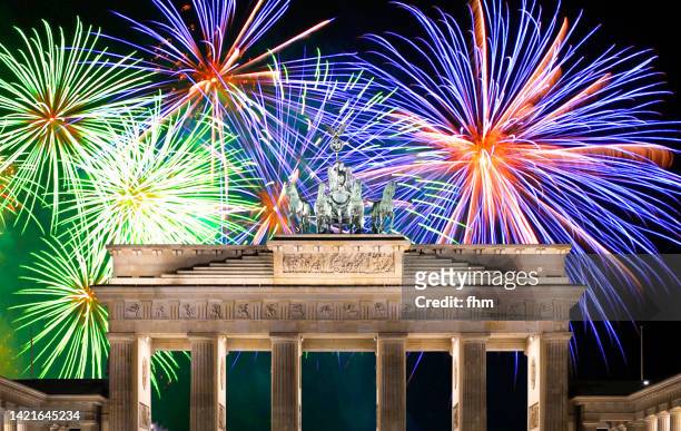 brandenburg gate with firework display (berlin, germany) - silvester berlin stock-fotos und bilder