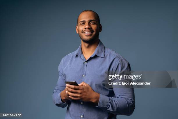 retrato de um empresário descontraído segurando smartphone - homens - fotografias e filmes do acervo