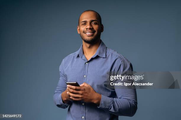 portrait of a relaxed businessman holding smartphone - business man isolated bildbanksfoton och bilder