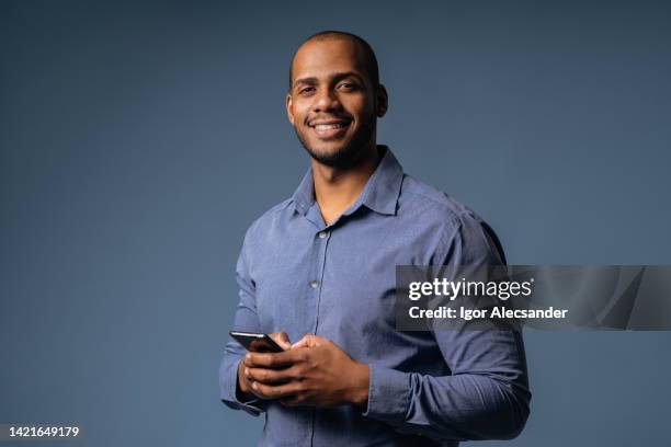 portrait of a relaxed businessman holding smartphone - businessman cut out stockfoto's en -beelden