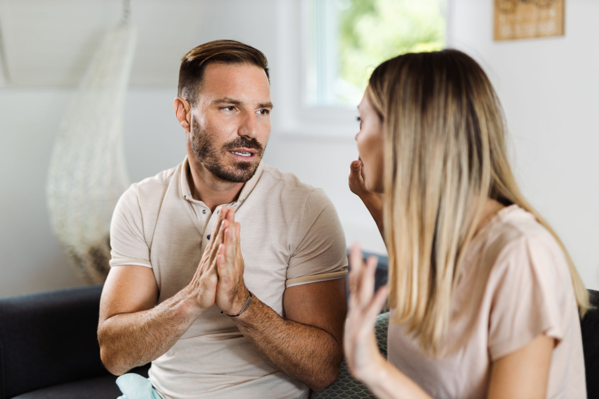Mid adult man asking his girlfriend for forgiveness at home Mid adult man asking his girlfriend for forgiveness at home