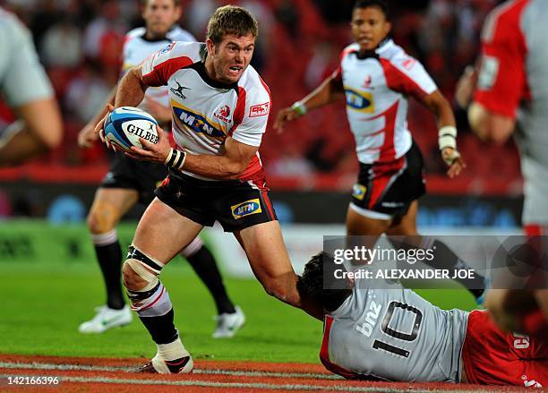 Taute Rsa Lions Outside Centre Jaco Taute is tackled by Crusaders Dan Carter ...