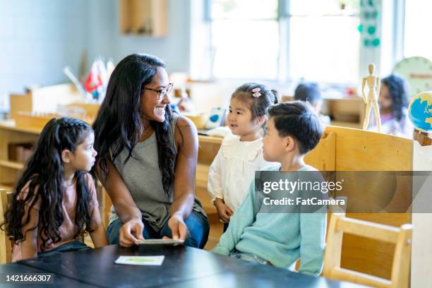 montessori teacher working with children - kids reading in classroom stock pictures, royalty-free photos & images