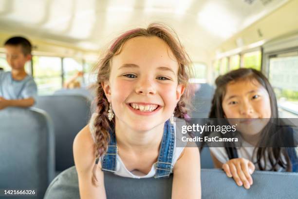 children riding the school bus - kids sitting together in bus stock pictures, royalty-free photos & images