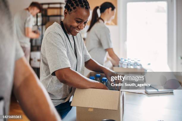 volunteers working together - non profit organization stock pictures, royalty-free photos & images