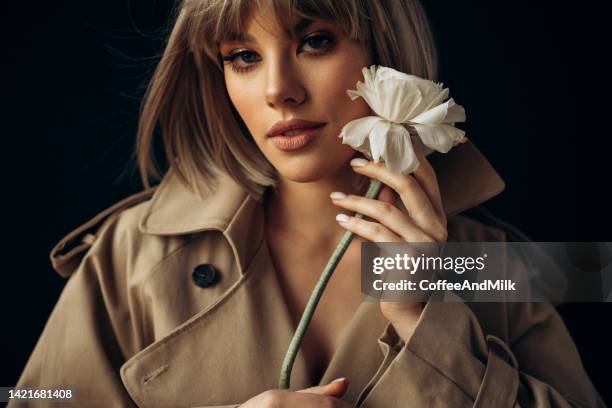 beautiful woman holding a flower - short hair model stock pictures, royalty-free photos & images