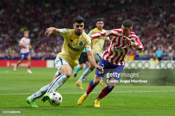 Mehdi Taremi of FC Porto turns with the ball under pressure from Jose Gimenez of Atletico de Madrid during the UEFA Champions League group B match...