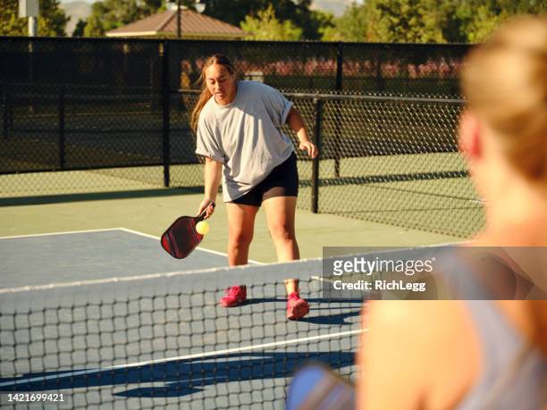 young adults playing pickleball on a public court - doubles sports stock pictures, royalty-free photos & images