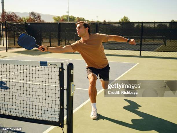 giovani adulti che giocano a pickleball su un campo pubblico - paddle tennis foto e immagini stock