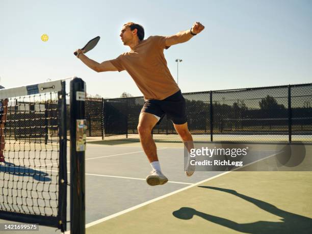 giovani adulti che giocano a pickleball su un campo pubblico - paddle tennis foto e immagini stock