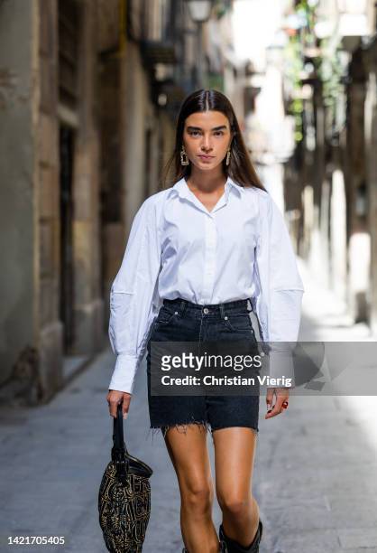 Model Martina Canales wears white shirt from Cos, earrings, black bermudas jeans from Bershka, cowboy boots from Au Revoir Cinderella, Bag from...