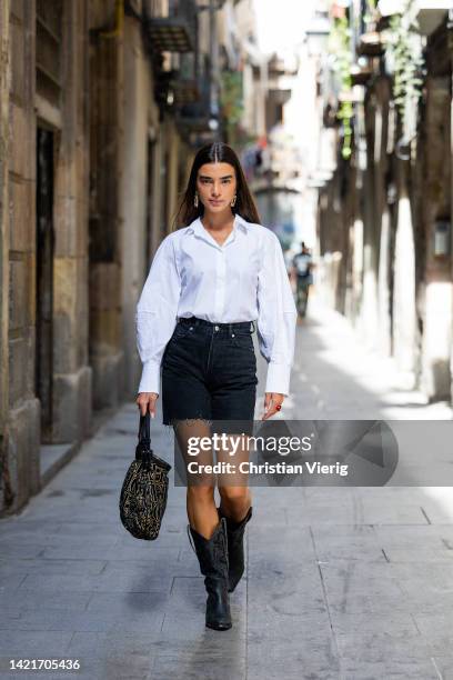Model Martina Canales wears white shirt from Cos, earrings, black bermudas jeans from Bershka, cowboy boots from Au Revoir Cinderella, Bag from...