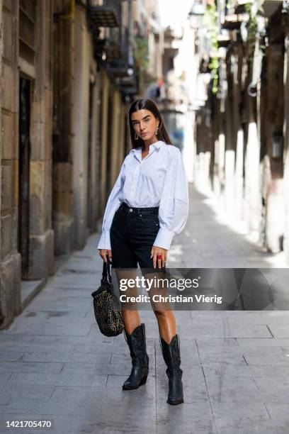 Model Martina Canales wears white shirt from Cos, earrings, black bermudas jeans from Bershka, cowboy boots from Au Revoir Cinderella, Bag from...