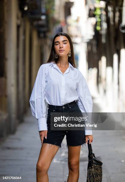 Model Martina Canales wears white shirt from Cos, earrings, black bermudas jeans from Bershka, cowboy boots from Au Revoir Cinderella, Bag from...