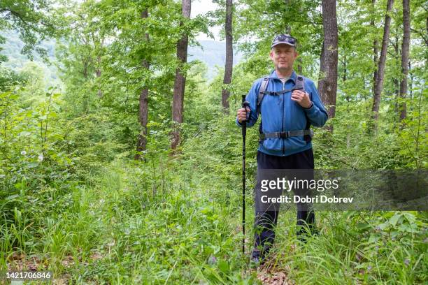 a middle-aged man is engaged in mountain tourism. - grijze hoed stockfoto's en -beelden