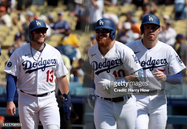 Justin Turner of the Los Angeles Dodgers celebrates his three run homerun with Max Muncy and Freddie Freeman, to take a 3-2 lead over the San...