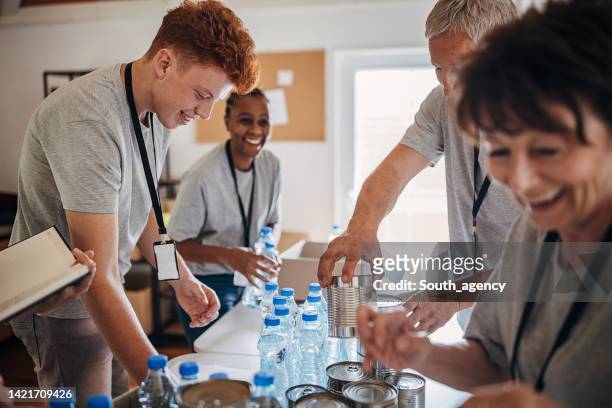 people sorting donations together - planned giving stock pictures, royalty-free photos & images