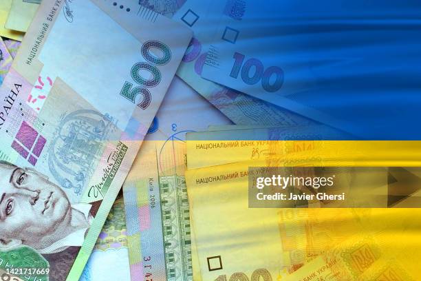 hryvnia cash banknotes and ukraine flag - ukrainian money - international monetary fund stock pictures, royalty-free photos & images