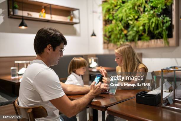 customer consulting the restaurant menu by qr code - family ordering at restaurant stock pictures, royalty-free photos & images