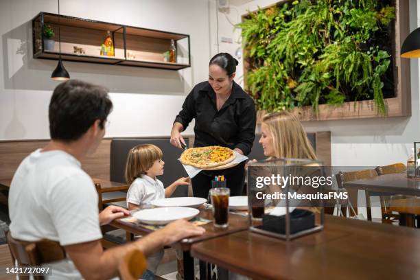 waitress serving pizza - pizzeria bildbanksfoton och bilder