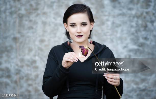 teenage girl holding a match to a rose. - rache stock-fotos und bilder
