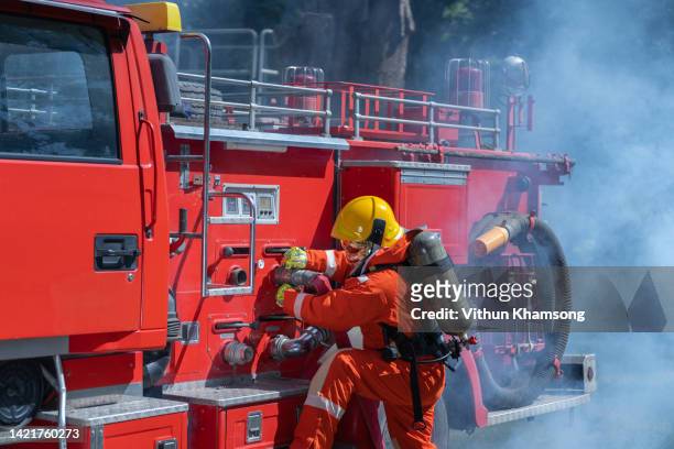 firefighter prepare equipment for emergency situation and fire engine. - quartel de bombeiros imagens e fotografias de stock