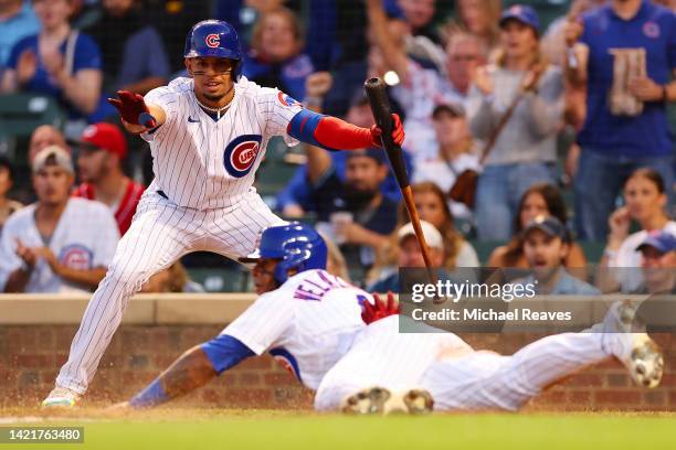 Christopher Morel of the Chicago Cubs celebrates with Nelson Velazquez as he safely scores a run against the Cincinnati Reds during the second inning...
