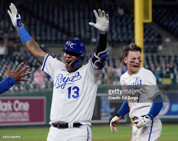 Salvador Perez of the Kansas City Royals celebrates his walk-off sacrifice fly with Bobby Witt Jr. #7 in the ninth inning against the Cleveland...
