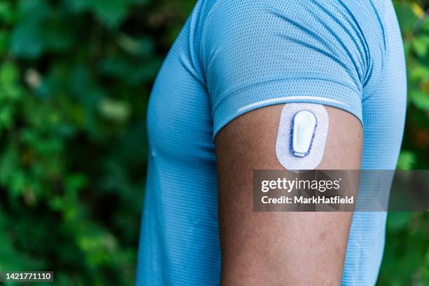 athlete with continuous glucose monitor transmitter - continuous glucose monitor stock pictures, royalty-free photos & images