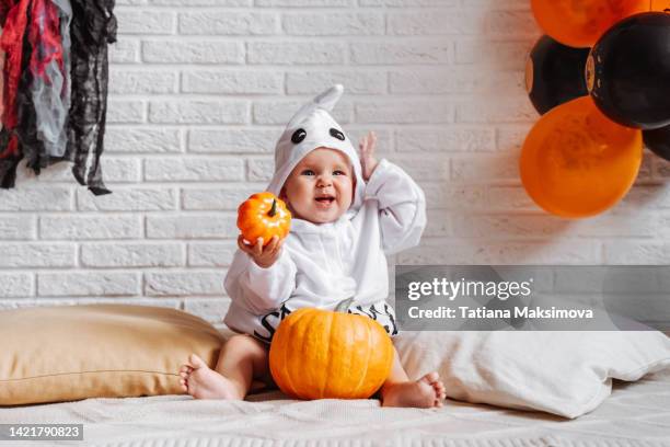 cute baby girl in ghost costume celebrate halloween at home. - ghost player stock pictures, royalty-free photos & images