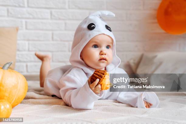 cute baby girl in ghost costume celebrate halloween at home. - ghost player stock pictures, royalty-free photos & images