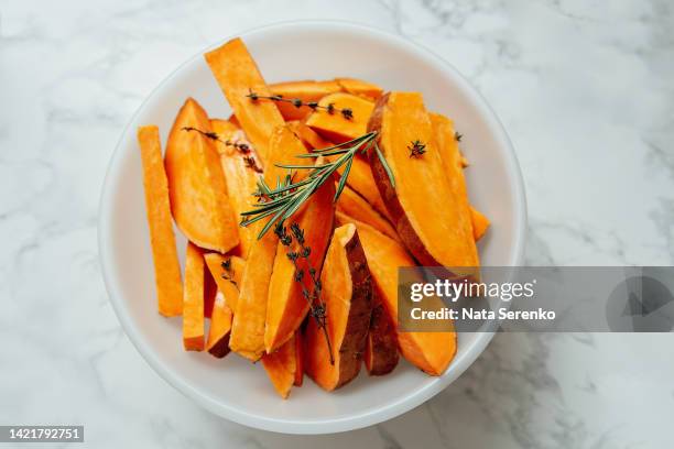 raw diced sweet potato in a bowl on light background - zoete aardappel stockfoto's en -beelden