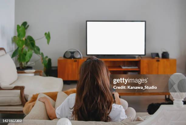 indonesian woman binge watching her favourite tv show - watching tv rear view stock pictures, royalty-free photos & images