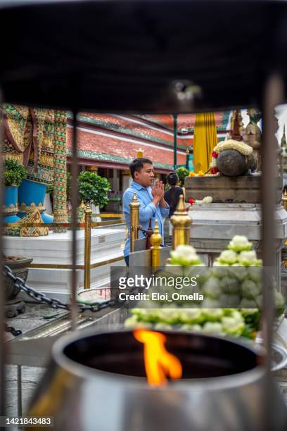 adult man praying at temple of the emerald buddha - wat phra si rattana satsadaram (wat phra kaew) - the emerald buddha temple in bangkok stock pictures, royalty-free photos & images