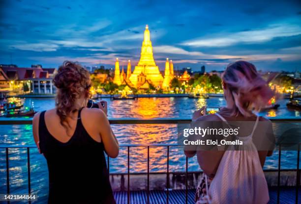 tourists taking a photo of wat arun temple at night, bangkok. thailand - bangkok imagens e fotografias de stock