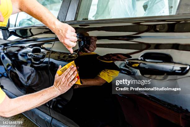 a car maintenance man is polishing the car in auto service. - karosseriarbete bildbanksfoton och bilder