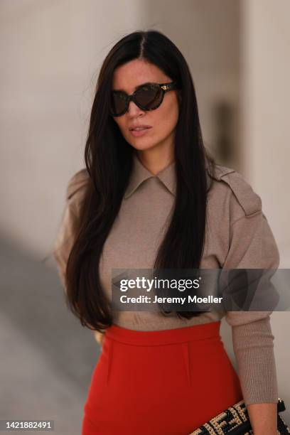 Leo Eberlin is seen wearing brown Bottega Veneta shades, beige cashmere pullover from Victoria Beckham, red Roland Meuret long pencil skirt and...