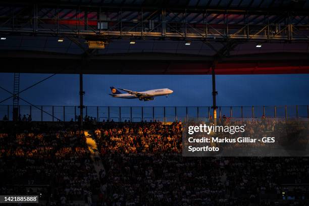 Lufthansa airplane is behind the fans on approach to Frankfurt Airport during the UEFA Champions League group D match between Eintracht Frankfurt and...