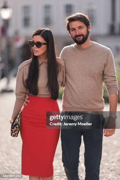 Leo Eberlin is seen wearing brown Bottega Veneta shades, beige cashmere pullover from Victoria Beckham, red Roland Meuret long pencil skirt,...