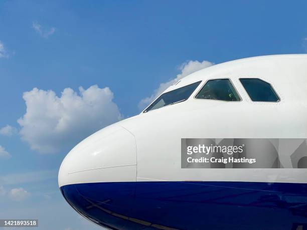 macro extreme close up side view of white commercial flight airplane cockpit on stand after landing at the airport runway with no visible markings or livery. - airplane front view stock pictures, royalty-free photos & images