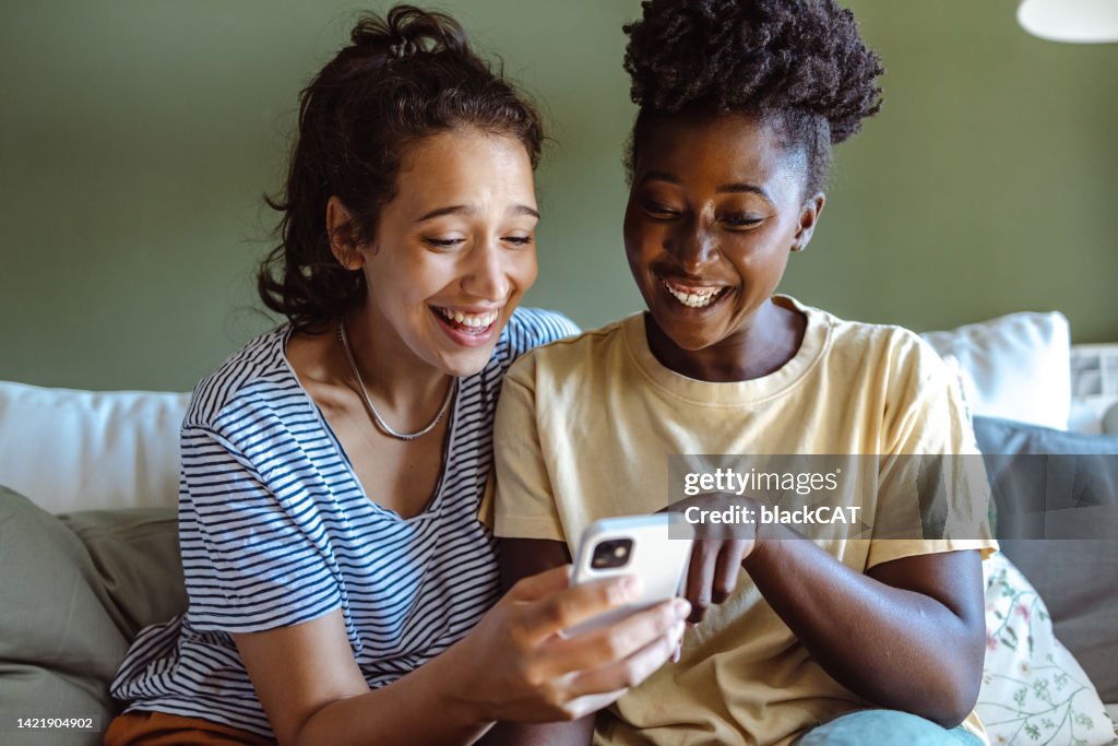 Two Young Women Use Smart Phones At Home High-Res Stock Photo - Getty ...