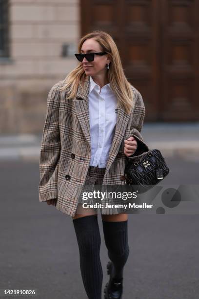 Sonia Lyson is seen wearing black Celine shades, Miu Miu white blouse, Miu Miu matching checked tweed oversized blazer and Miu Miu mini skirt, Miu...