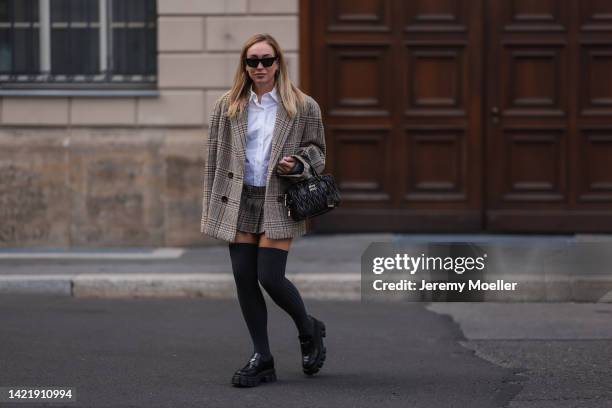 Sonia Lyson is seen wearing black Celine shades, Miu Miu white blouse, Miu Miu checked tweed oversized blazer and matching Miu Miu mini skirt, Miu...