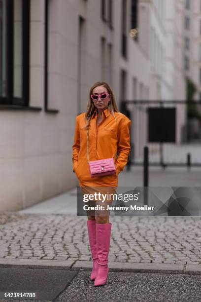 Sonia Lyson is seen wearing pink Chiara Ferragni shades, orange Remain leather mini dress, Jimmy Choo pink leather Dreece Knee Boot 95 and Jimmy Choo...